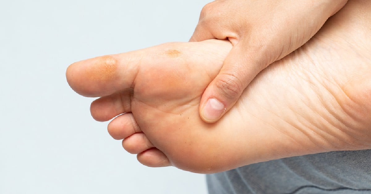 Person rubbing foot due to diabetic foot pain